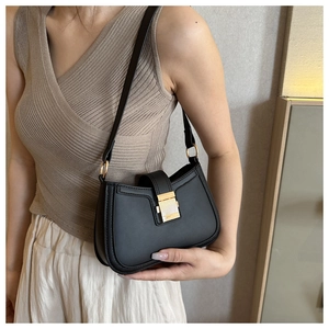Détail d'un sac à bandoulière noir minimaliste avec boucle en métal doré pour femmes