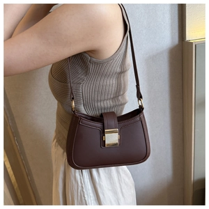 Sac baguette chic en similicuir marron foncé avec boucle dorée porté par un mannequin