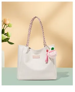 Détail du sac cabas blanc à motif pied-de-poule, bandoulière tissée et bijou en peluche