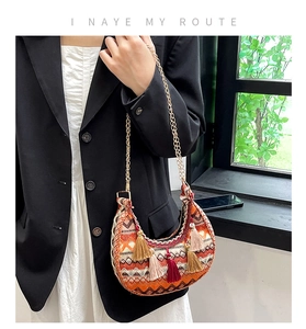 Gros plan sur un sac selle bohème avec motifs tissés colorés et pompons décoratifs