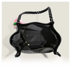 Vue de dessus d'un sac cabas noir tressé montrant l'intérieur et le charm pêche