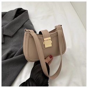 Détail du sac baguette beige clair en similicuir avec boucle métallique rectangulaire dorée