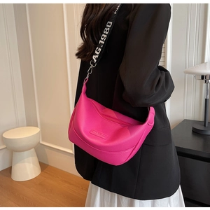 Détail du sac dumpling en cuir rose avec large bandoulière tissée lettrée BAG 1980