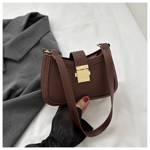 Détail du sac selle marron vintage avec cuir texturé et boucle en métal doré carré