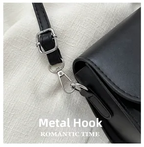 Detail of hardware hook and silver buckle on black leather crossbody bag for women