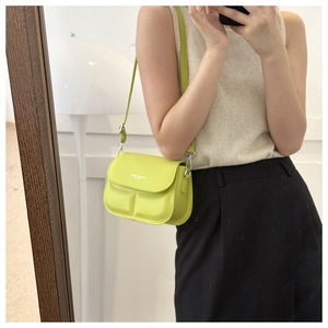 Detail van de limoengroene crossbodytas met gewatteerde textuur en zilveren metalen gesp
