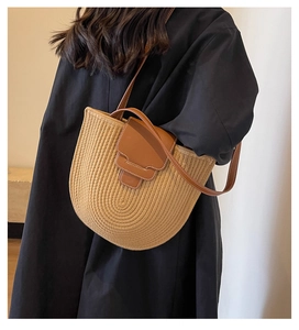 Close-up of woven bucket bag with brown leather flap and contrast stitching details