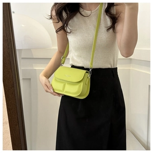 Detail of lime green crossbody bag with 3D embossed square pattern on high-quality leather