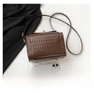 Borsa a tracolla in pelle marrone con smartphone per il confronto delle dimensioni