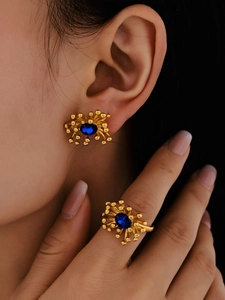 Close-up of 18K gold plated earring and ring set featuring blue oval zircon stones