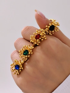 Macro detail of vintage 18K gold plated flower rings with colorful oval zircon gemstones