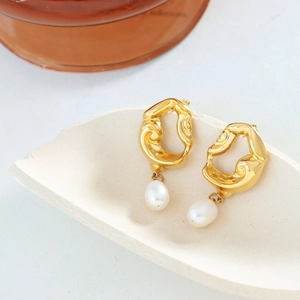 Boucles d'oreilles perles baroques vintage avec design creux doré sur socle crème