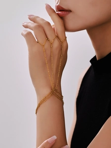 Detail of a layered gold finger bracelet hand harness with delicate ball bead chains