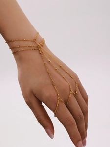 Detailed view of layered gold stainless steel slave bracelet with small bead accents