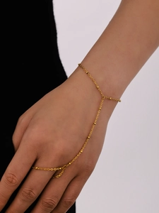 Detailed close-up of 18k gold plated finger bracelet featuring delicate beads and chain