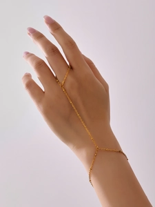 Detail of gold-plated stainless steel slave bracelet with small beads on hands