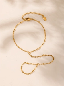 Detail of golden stainless steel slave bracelet with bead chain design and S.Steel tag