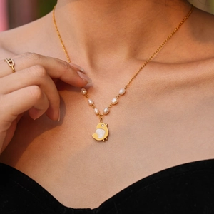 Goldene Küken-Halskette mit Muschel-Inlay und Süßwasserperlen an elegantem weiblichem Modell