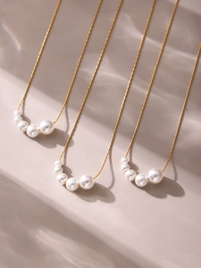 Detail of 18k gold plated stainless steel necklace with five graduated white pearls
