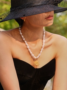 Macro detail of ocean style beaded necklace with shell pendant on elegant model