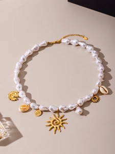 Detailed shot of ocean-style necklace with baroque pearls and gold sun charms