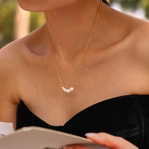18K gold plated stainless steel necklace with five graduated white pearls on a model