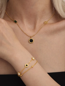 Details von Goldhalskette und zweilagigem Armband Set mit schwarzen und grünen Anhängern