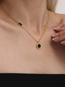 Detail der Goldkette mit grünem Edelstein und Blumenanhänger am weiblichen Model