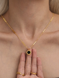 Nahaufnahme der goldenen Halskette mit römischem Ziffernring und passendem Ring