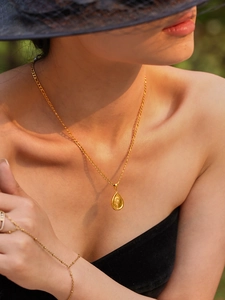 Détail d'un collier plaqué or 18k avec pendentif tournesol porté par un mannequin