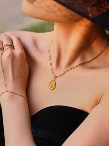 Détail du collier plaqué or 18k avec pendentif tournesol sous une lumière naturelle