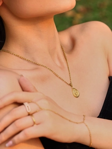 Détail d'un collier doré 18 carats avec pendentif tournesol et relief floral pour femme
