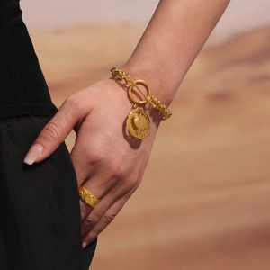 Gold OT toggle chain bracelet with round coin pendant and textured ring on wrist
