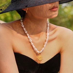 Bohemian baroque pearl necklace with golden sun pendant and starfish shell accents