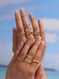 Set di anelli bohémien placcati in oro con forme geometriche indossati all'aperto