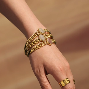 Three-piece gold Cuban link chain bracelets with oval rhinestone charms and wide engraved ring