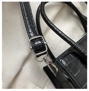 Close-up of black stone pattern tote bag showing adjustable silver buckle and glossy texture