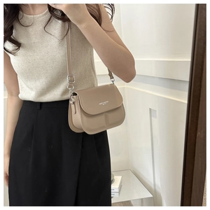 Detail van kaki crossbodytas met wit Fashion Trend-logo en zilverkleurige hardware