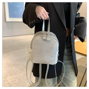 Vue détaillée d'un mini sac à dos argenté avec strass brillants et fermeture éclair double