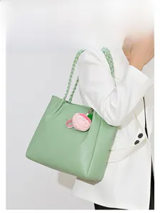 Détail du sac cabas vert clair à motif pied-de-poule avec poignées tressées
