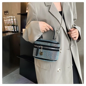 Detail of colorful rhinestones on a black mini box bag with silver chain strap