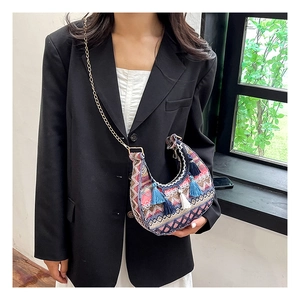 Gros plan sur un sac de selle bohème avec tissage géométrique et pampilles à franges