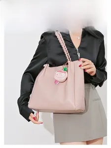 Vue détaillée du sac cabas en cuir rose avec motif gaufré et bandoulière tissée