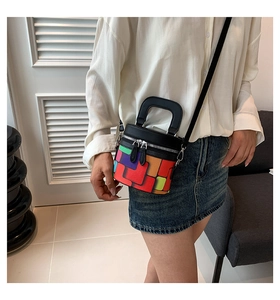 Detailed view of colorful checkered cylinder bag worn by a model in a minimal setting