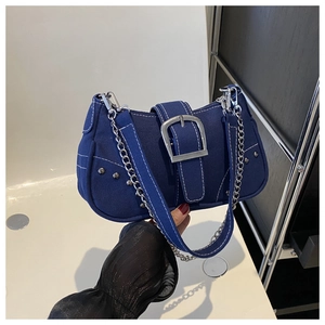 Close-up of blue denim shoulder bag featuring white contrast stitching and silver studs