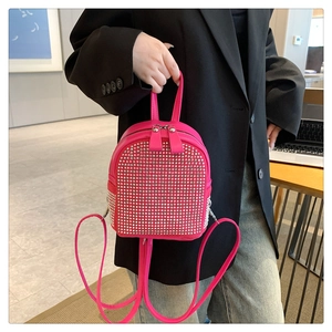 Détail d'un mini sac à dos rose fuchsia avec strass brillants et doubles bretelles