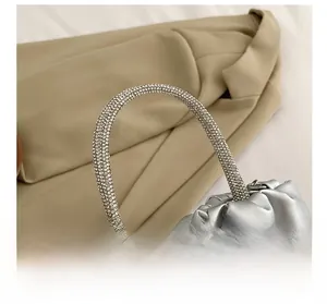 Detailed close-up of sparkling rhinestone handle and silver pleated crossbody bag