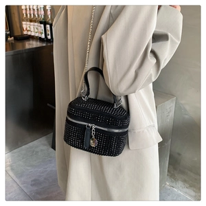 Close-up of a black crossbody bag featuring shiny rhinestones and silver chain strap
