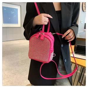 Mini sac à dos rose vif orné de strass argentés porté avec des sangles réglables
