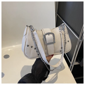 Detail of cream canvas underarm bag with silver buckle and metal chain strap decoration